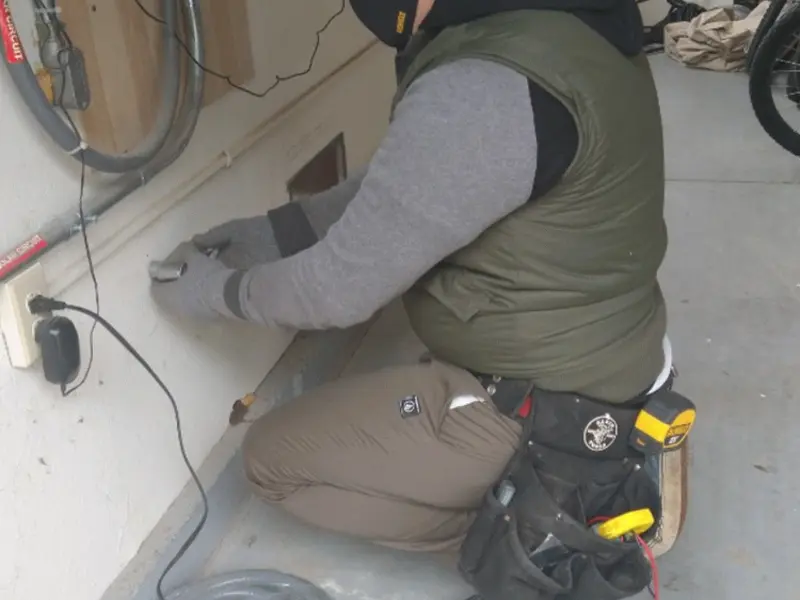 Electrician performing outlet wiring in a Miami garage